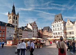 a group of people walking around a city with buildings at Gemütliches Apartment Nähe Bahnhof in Trier