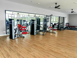 a gym with treadmills and chairs in a room at Alanis Residence Room Sepang KLIA Kota Warisan in Sepang