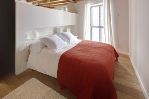 ein Schlafzimmer mit einem Bett mit einer roten Decke und einem Fenster in der Unterkunft Val Arties 1 by FeelFree Rentals in Arties