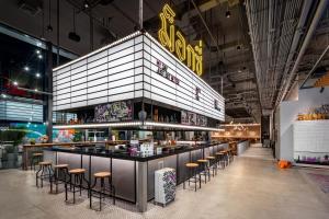 Moxy Bangkok Ratchaprasong في بانكوك: مطعم مع بار مع المقاعد