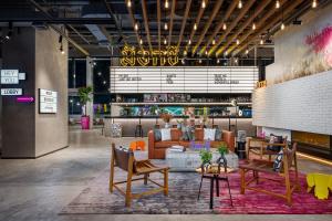 a rendering of a lobby with a couch and chairs at Moxy Bangkok Ratchaprasong in Bangkok