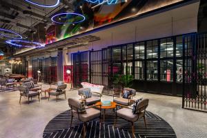 a waiting area with chairs and a table in a room at Moxy Bangkok Ratchaprasong in Bangkok