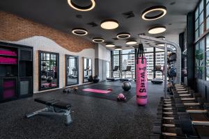 a gym with a pink treadmill and exercise equipment at Moxy Bangkok Ratchaprasong in Bangkok