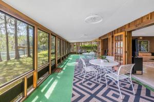 a room with a table and chairs and windows at Rainbow River Estate on Blue Run in Dunnellon