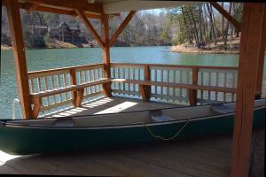 um barco sentado numa doca num lago em Lake Lure Retreat - A Beautiful Lakefront Lodge on Mirror Lake-Waterfront-Newly Expanded Deck lodge em Lake Lure
