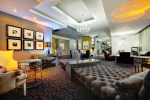 uma grande sala de estar com sofás e mesas em Protea Hotel Fire & Ice! by Marriott Johannesburg Melrose Arch em Joanesburgo