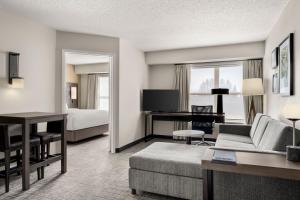 a hotel room with a couch and a bed and a desk at Residence Inn by Marriott Davenport in Davenport