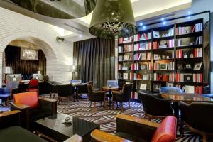 a library with tables and chairs and bookshelves at Protea Hotel Fire & Ice! by Marriott Johannesburg Melrose Arch in Johannesburg