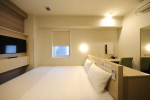 Smile Hotel Osaka Tennoji في أوساكا: غرفه فندقيه سرير وتلفزيون