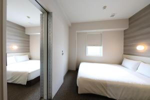 Postel nebo postele na pokoji v ubytování Smile Hotel Osaka Tennoji