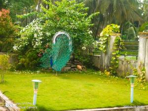 a peacock sculpture in a yard with a garden at His Grace Holiday Home - Nr to Malpe Beach in Udupi