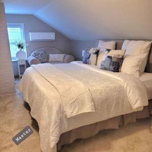 a bedroom with a large bed with pillows at Cozy Cottage in Louisville in Louisville