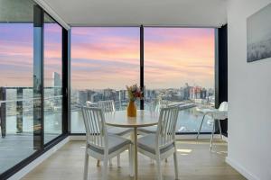 a dining room with a table and chairs and a view at Wake Up in Front of Water Bay Beckons- 2B2B1C in Melbourne