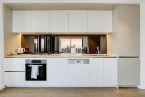 a kitchen with white cabinets and a sink at Wake Up in Front of Water Bay Beckons- 2B2B1C in Melbourne