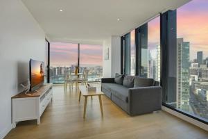 a living room with a couch and large windows at Wake Up in Front of Water Bay Beckons- 2B2B1C in Melbourne