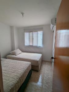 a bedroom with two beds and a window at Apartamento en Cartagena cerca del aeropuerto in Cartagena de Indias
