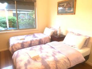 een slaapkamer met 2 bedden en een raam bij Ideal accommodation in Glen Waverley in Glen Waverley