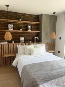 Un dormitorio con una cama grande y una pared de ladrillo. en Casa Berlín, Lake Access, en Guatapé 28 fotos más