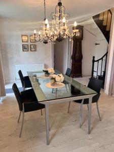 uma mesa de jantar com cadeiras e um lustre em Entire villa only 35 minutes from Puy du Fou em La Chapelle-Saint-Étienne