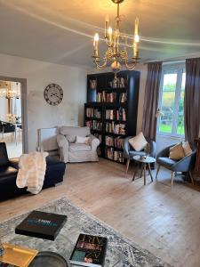 uma sala de estar com um sofá e um lustre em Entire villa only 35 minutes from Puy du Fou em La Chapelle-Saint-Étienne