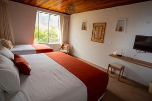 ein Hotelzimmer mit 2 Betten und einem TV in der Unterkunft Hotel El Abuelo in Carhuaz