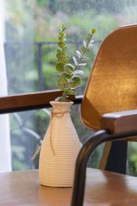 a white vase with a plant in it on a table at CODOTEL 86 in Ho Chi Minh City