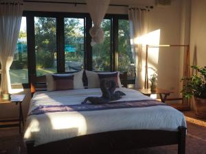 a bedroom with a large bed with a large window at Countryside getaway home (inc breakfast) in Chiang Mai