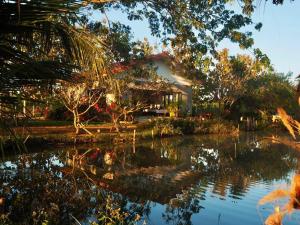 ein Haus mit einem Teich davor in der Unterkunft Countryside getaway home (inc breakfast) in Chiang Mai