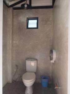 a bathroom with a toilet and a window on the wall at Countryside getaway home (inc breakfast) in Chiang Mai