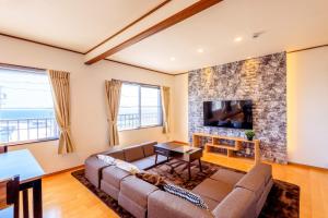 a living room with a couch and a tv at Minamichita Seaside Villa - Vacation STAY 14160 in Minamichita