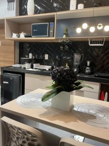 a kitchen with a table with a vase of flowers on it at Flat jk 02 térreo in Juazeiro do Norte