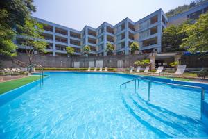 una gran piscina frente a un edificio en Reyzenit Kinosaki Suite VILLA, en Toyooka