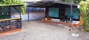 una pequeña casa con techo negro en Cabaña que Tuanis en Fortuna