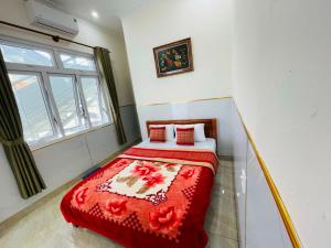 a bedroom with a bed with a red blanket at Phú Gia Hotel Bảo Lộc in Bao Loc