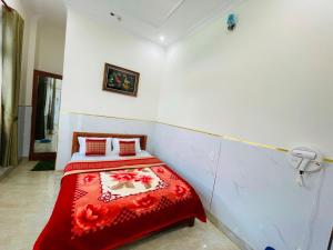 a bedroom with a bed with a red blanket at Phú Gia Hotel Bảo Lộc in Bảo Lộc