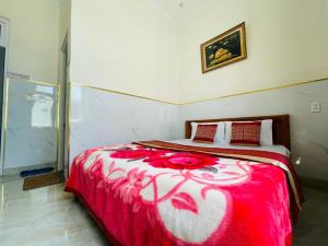 a bedroom with a bed with a red and white blanket at Phú Gia Hotel Bảo Lộc in Bao Loc