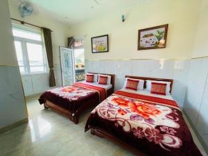 een slaapkamer met 2 bedden en een raam bij Phú Gia Hotel Bảo Lộc in Bao Loc