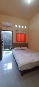 ein Schlafzimmer mit einem großen Bett und einem Fenster in der Unterkunft Angler Family Guest House in Karangtengah