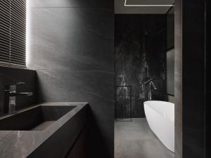 a black bathroom with a sink and a bath tub at Guangfa Apartment in Tainan +39 photos