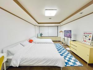 首爾的住宿－ChaenHaus，一间卧室设有两张床,铺有一个 ⁇ 板地板