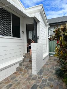 une femme debout à la porte d'une maison dans l'établissement Comfortable Beach Home Scarborough, à Scarborough