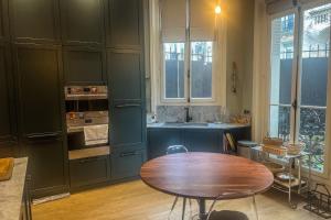 uma cozinha com uma mesa de madeira e um lavatório em Atypical house with garden em Paris