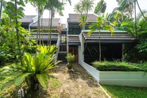 a house with a courtyard with palm trees at Kamala Beach Estate Resort - SHA Extra Plus in Kamala Beach
