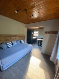 a bedroom with a large bed with a wooden ceiling at Casa en El Calafate, centro in El Calafate