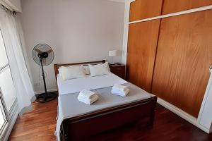1 dormitorio con 1 cama con 2 toallas en Hornera San Juan - Luminoso Apartamento con Balcón en Rosario
