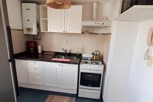 cocina con armarios blancos y fogones en Hornera San Juan - Luminoso Apartamento con Balcón en Rosario