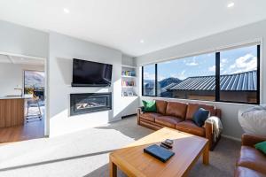 a living room with a couch and a fireplace at Stylish Panoramic Mountain and Lake Views in Wanaka