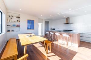 a kitchen and dining room with a wooden table and chairs at Stylish Panoramic Mountain and Lake Views in Wanaka