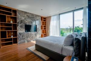 a bedroom with a large bed and a tv at Regal Victoria luxury villa in Trà Khê (1)