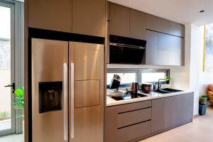 uma cozinha com um frigorífico de aço inoxidável em Regal Victoria luxury villa em Trà Khê (1)